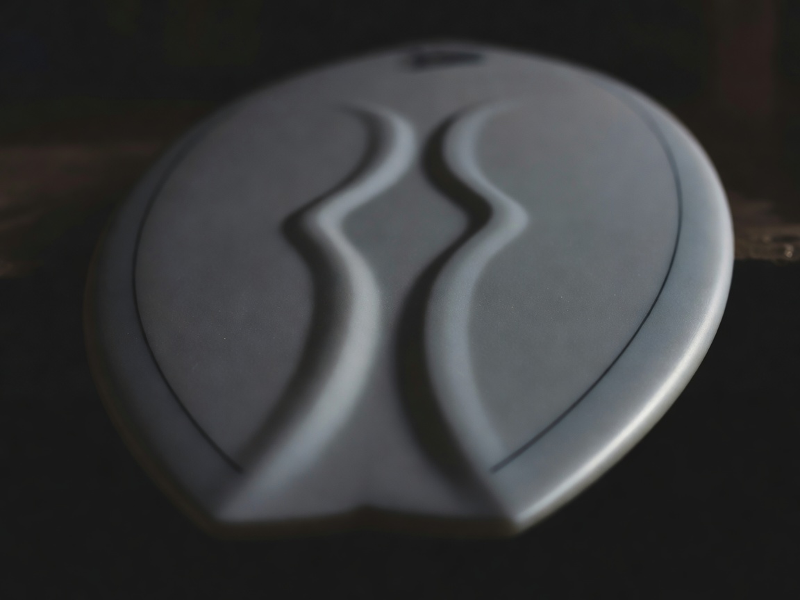 Underside of a shortboard showing single-to-double concave and a hard rail edge in low light